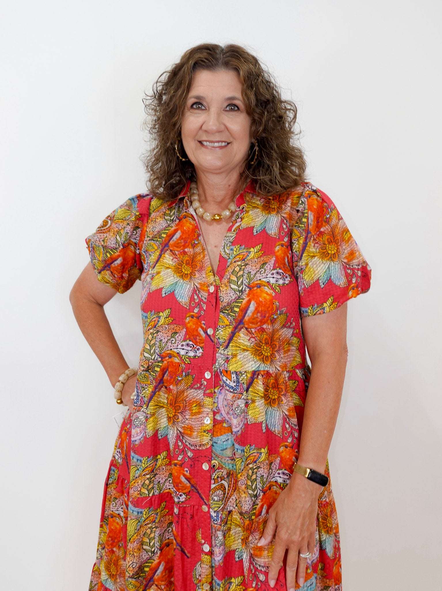 Woman wearing a colorful floral dress against a white background
