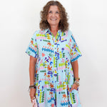 Woman wearing a colorful patterned dress against a white background