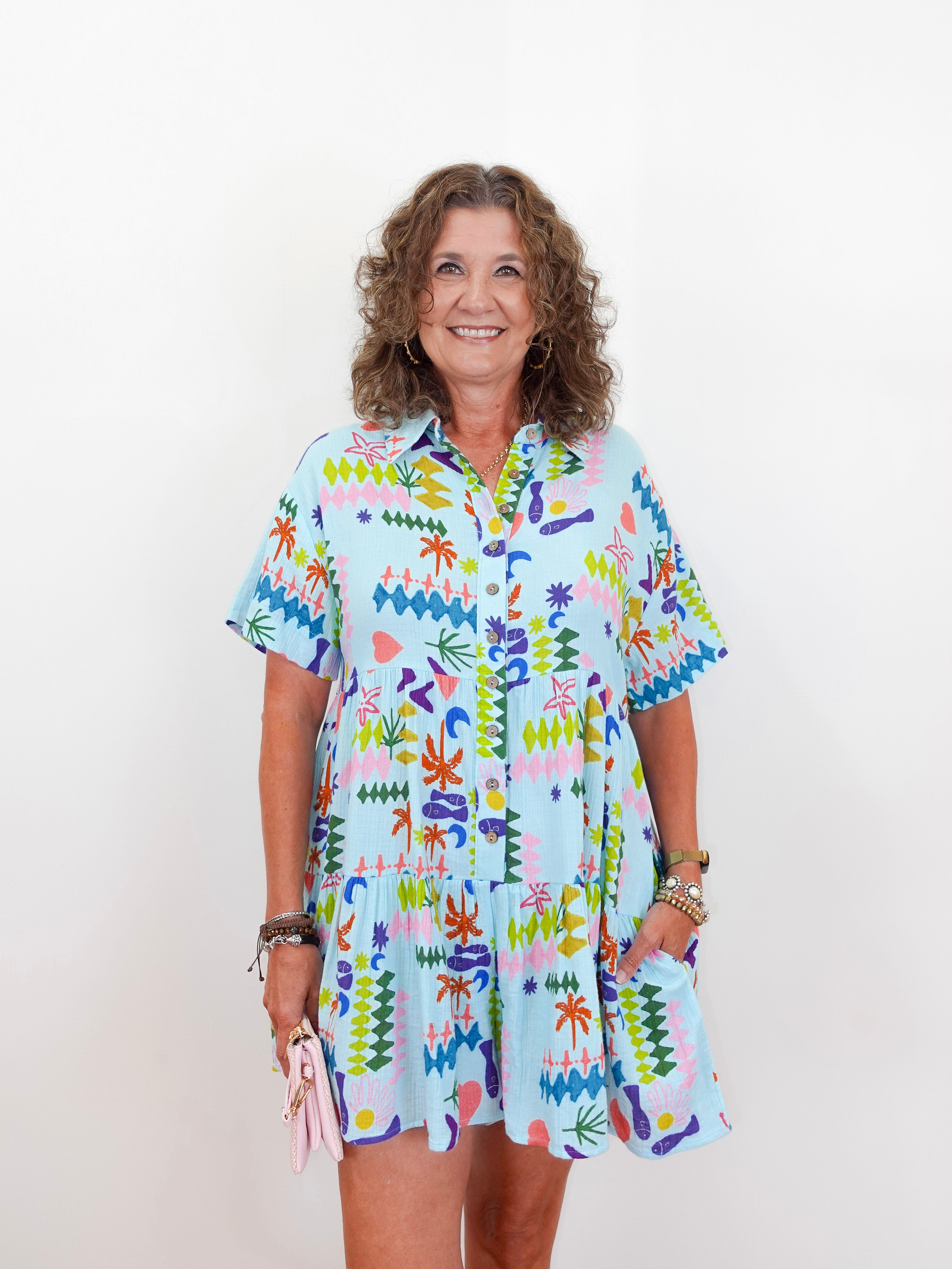 Woman wearing a colorful patterned dress against a white background
