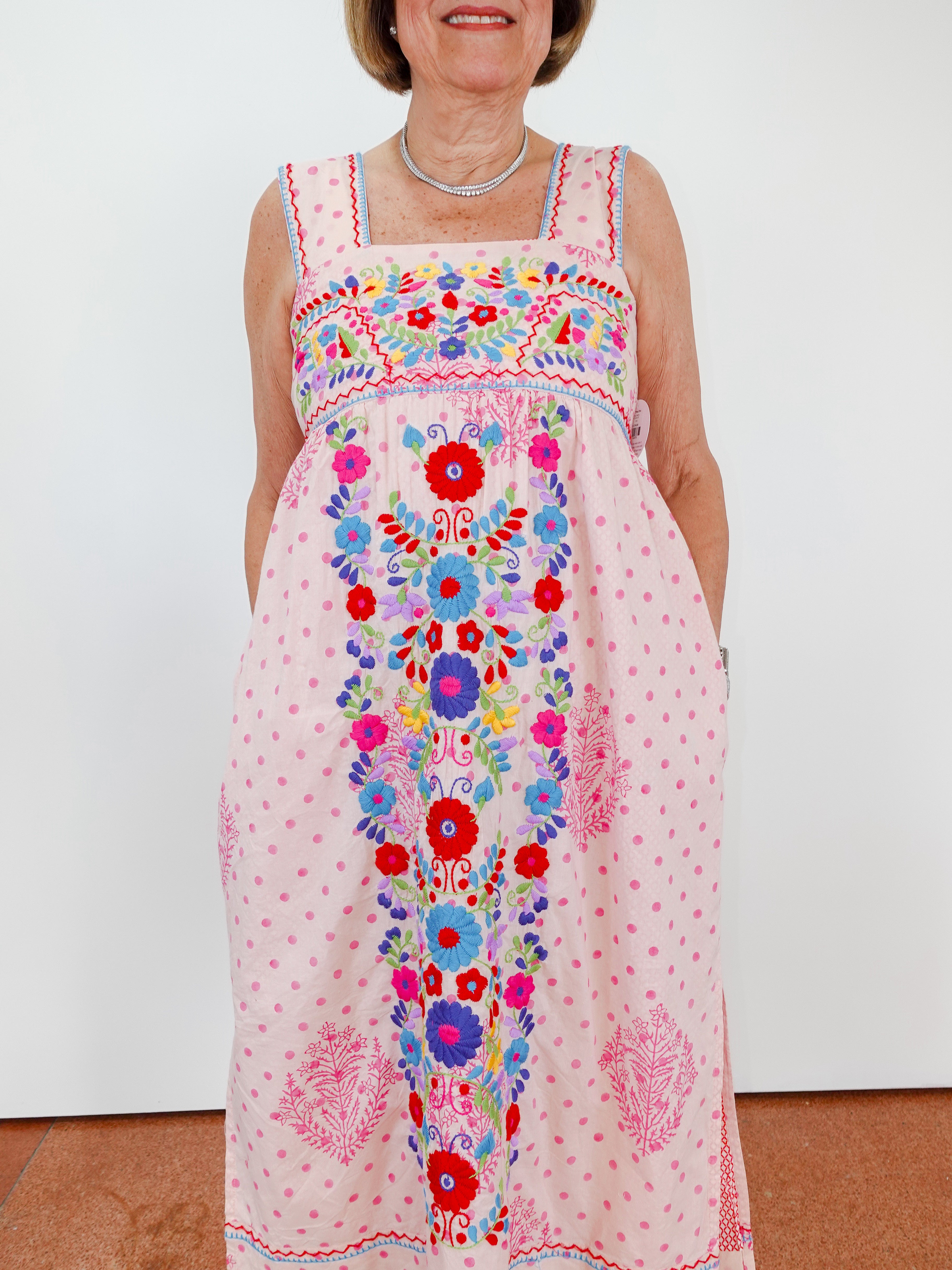 Woman wearing a colorful floral dress with a white background