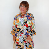 Woman wearing a colorful floral dress against a white background