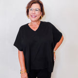 Woman wearing a black outfit with glasses against a white background