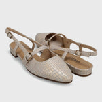 Pair of beige slingback shoes on a light gray background