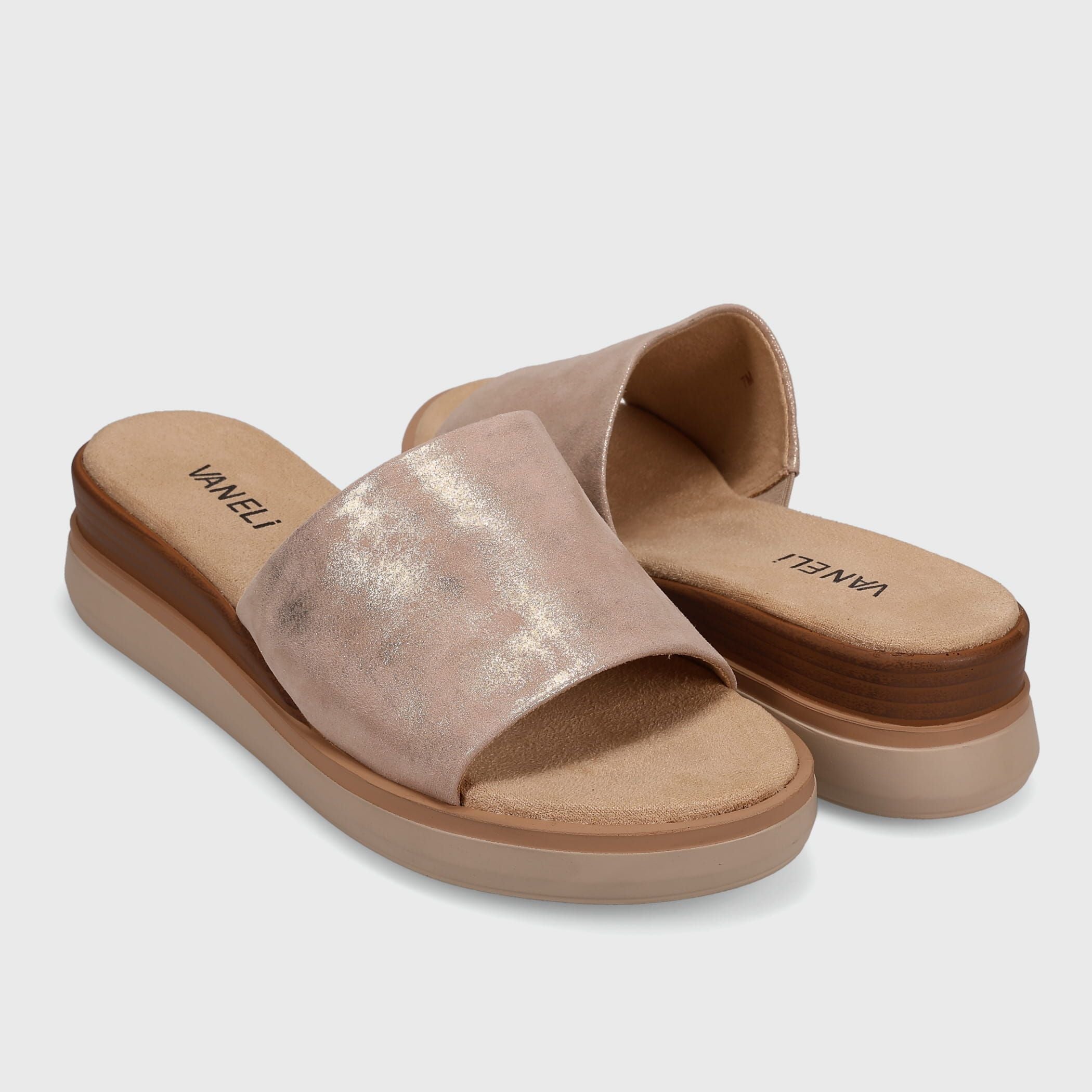 Pair of rose gold sandals with a brown sole on a light gray background