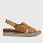Tan sandal with a platform sole on a light gray background