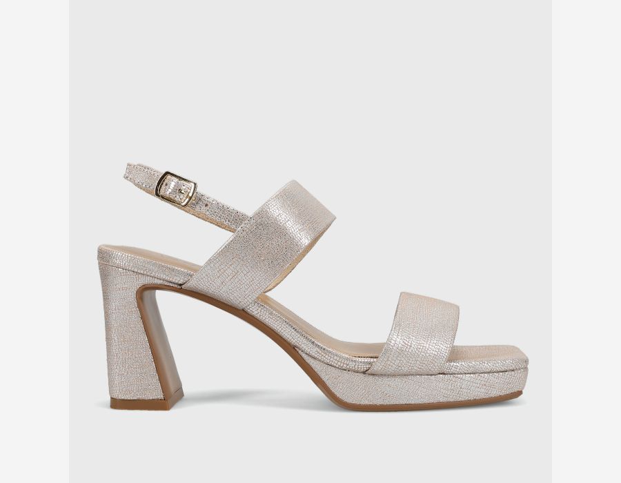 Silver glittery sandal with a block heel on a light gray background