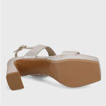 Beige sandal with a brown sole on a light gray background