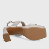 Beige sandal with a brown sole on a light gray background