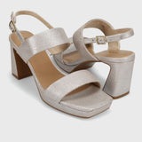 Pair of silver high-heeled sandals on a light gray background