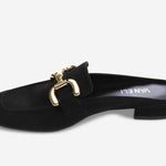 Black slip-on shoe with gold buckle on a white background