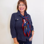 Woman wearing a navy leather shirt jacket in front a white background. 