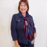 Woman wearing a navy leather shirt jacket in front a white background. 