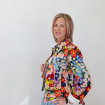 Woman wearing a colorful floral scarf against a white background