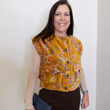 Woman wearing a floral patterned vest against a white background