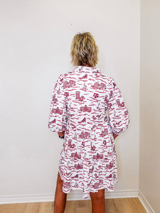 Person wearing a red and white patterned dress against a plain wall.