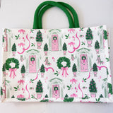 Tote bag with festive design featuring trees, wreaths, and pink ribbons on a white background.