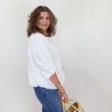 Woman holding a woven bag against a white background
