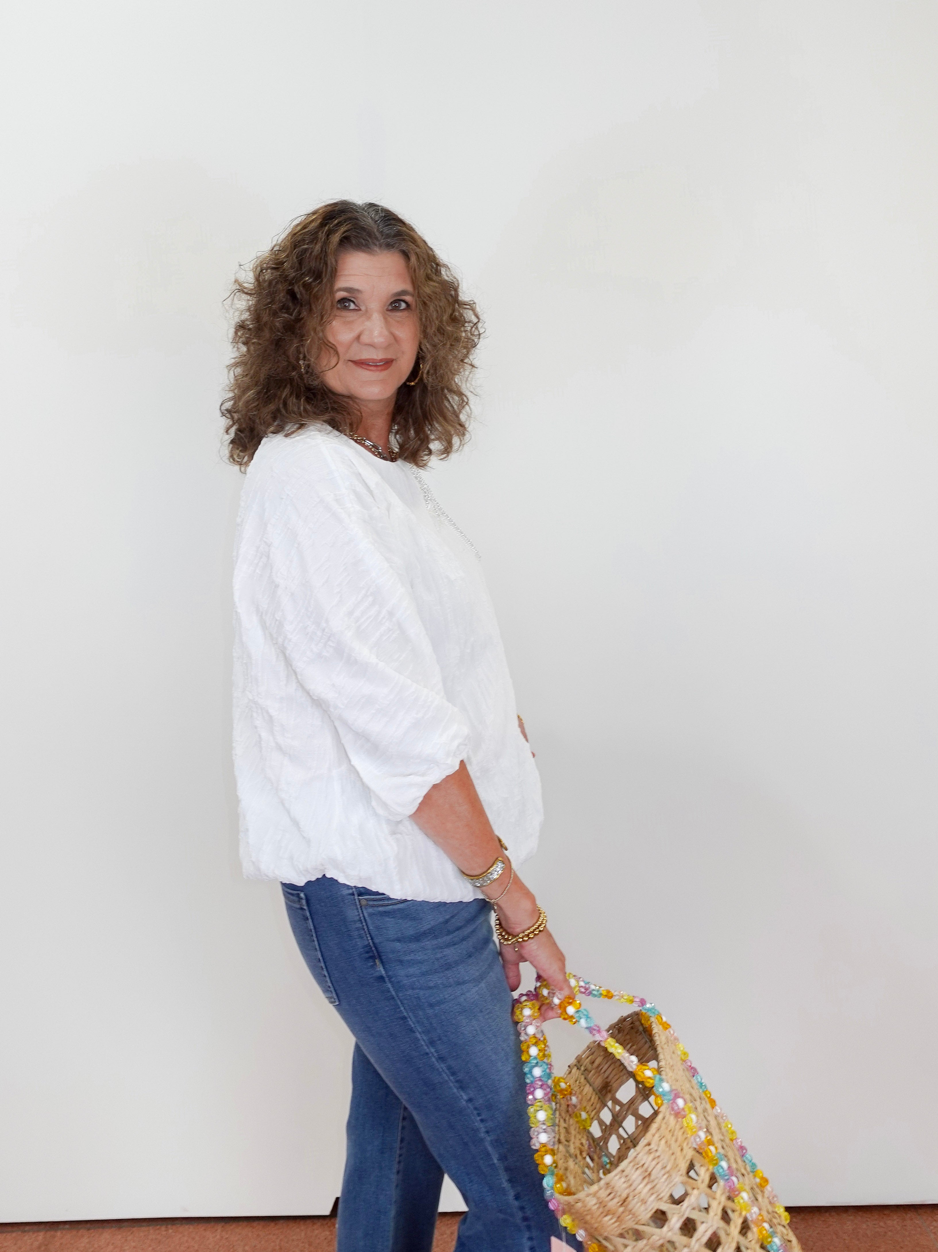 Woman holding a woven bag against a white background