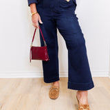 woman wearing a blue wide leg crop pant in front a white background.