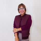 Woman wearing a purple jacket and glasses against a white background