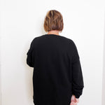 Person wearing a black sweater against a white background