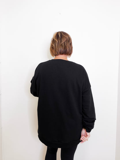 Person wearing a black sweater against a white background