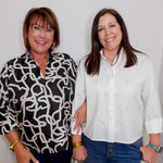Two women standing side by side against a plain background