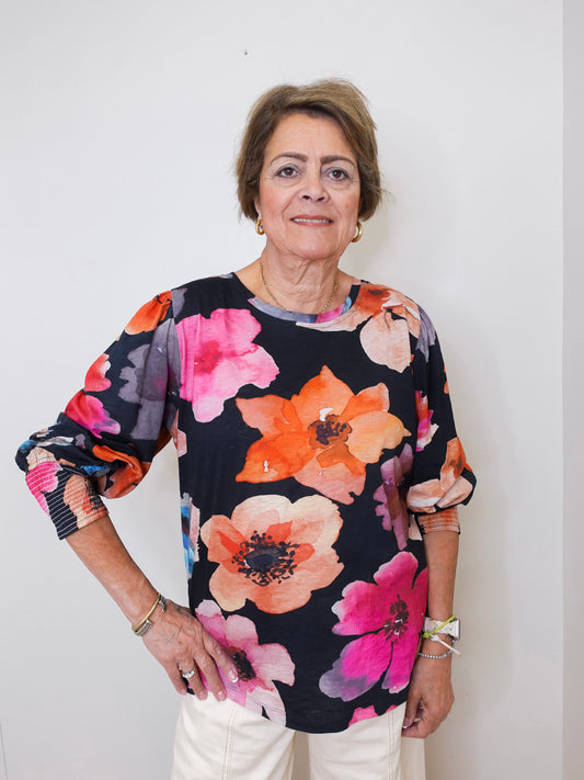Woman wearing a floral blouse against a plain background