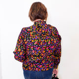 Person wearing a colorful floral shirt against a white background