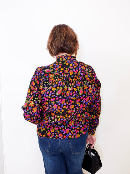 Person wearing a colorful floral shirt against a white background