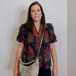woman wearing a gray suede handbag with braided handle on a white background