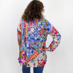 Person wearing a colorful patterned shirt with their back to the camera on a white background