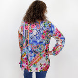 Person wearing a colorful patterned shirt with their back to the camera on a white background