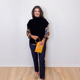 Woman holding a yellow handbag against a white wall