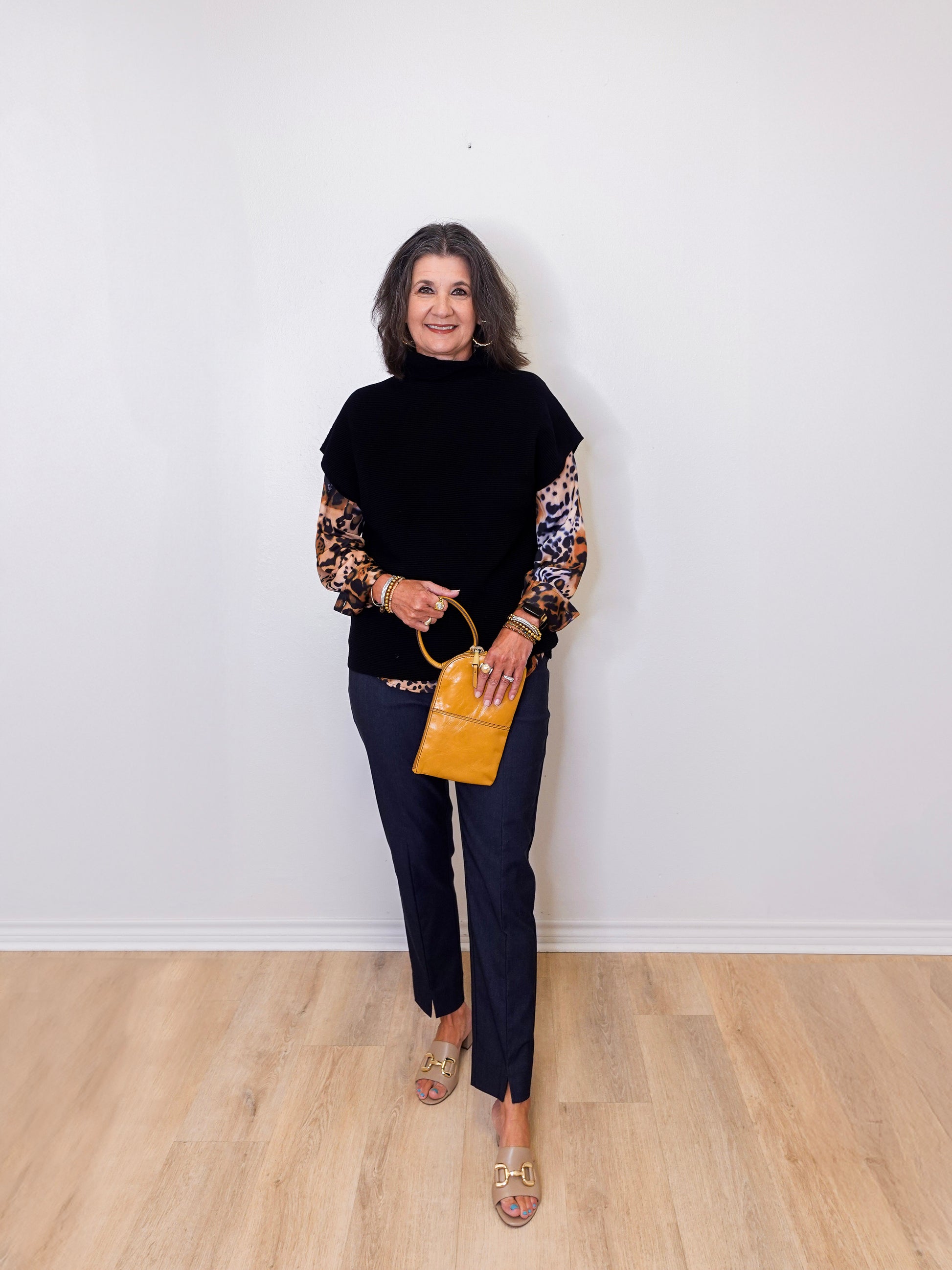 Woman holding a yellow handbag against a white wall