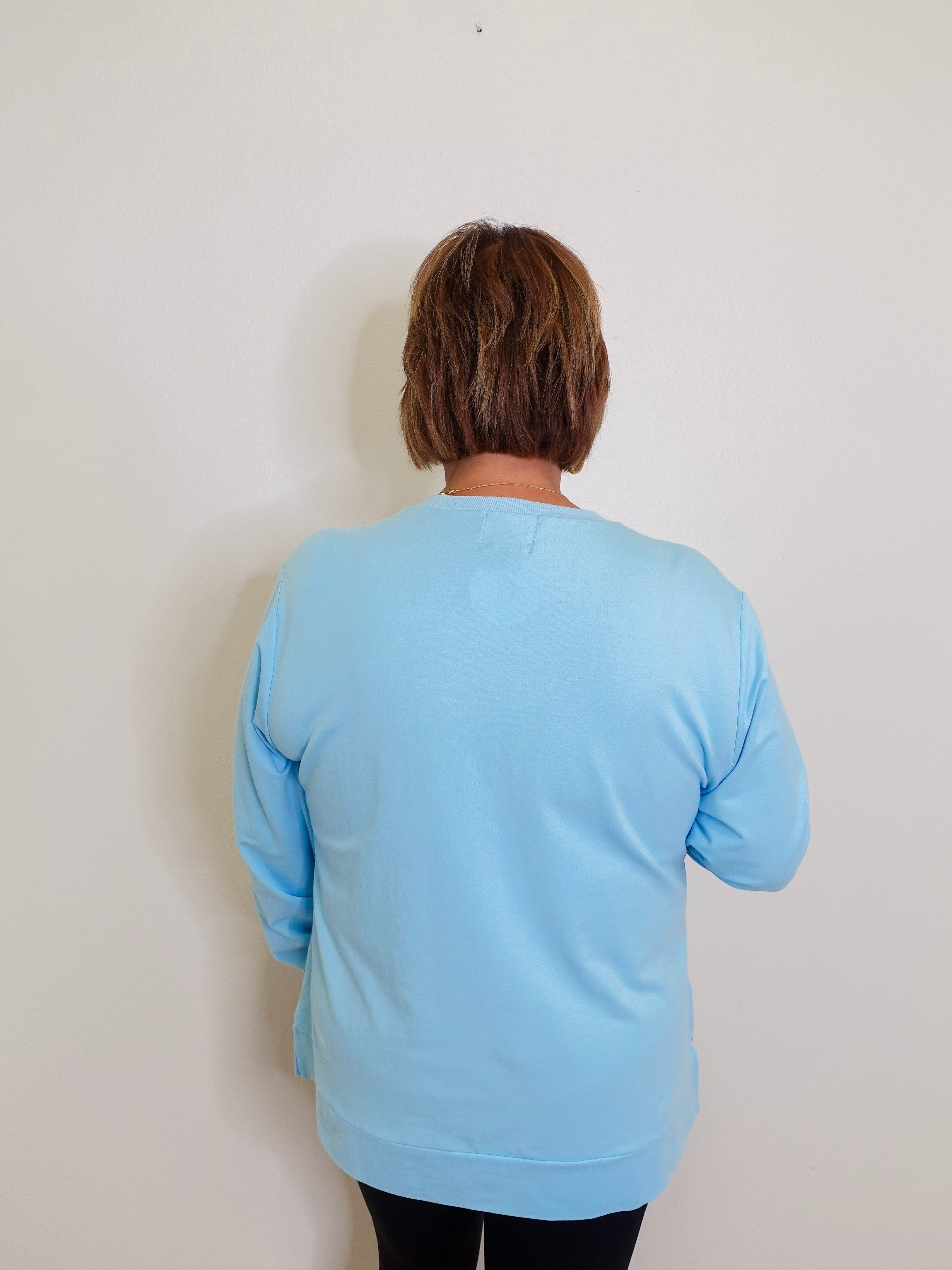 woman blue holiday knit top against a white background 