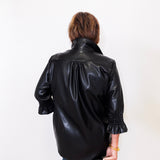 Person wearing a black leather jacket on a white background
