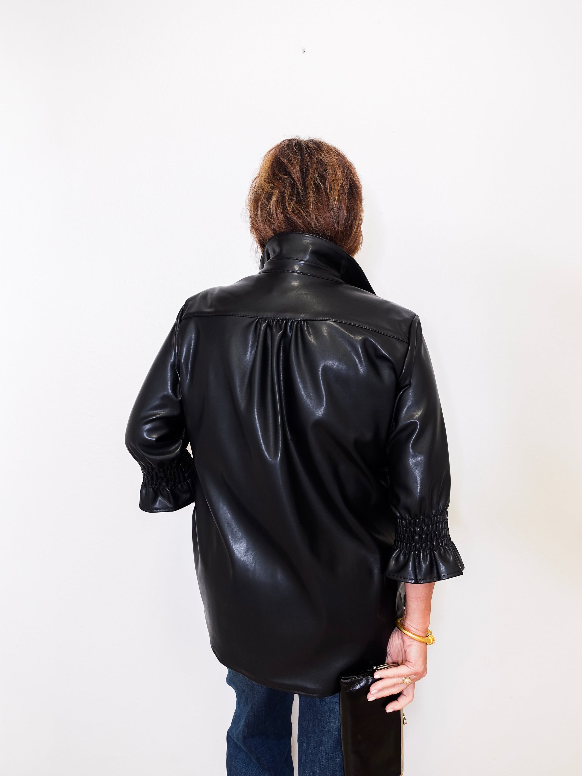 Person wearing a black leather jacket on a white background