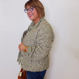 Woman wearing a patterned jacket and scarf against a white background