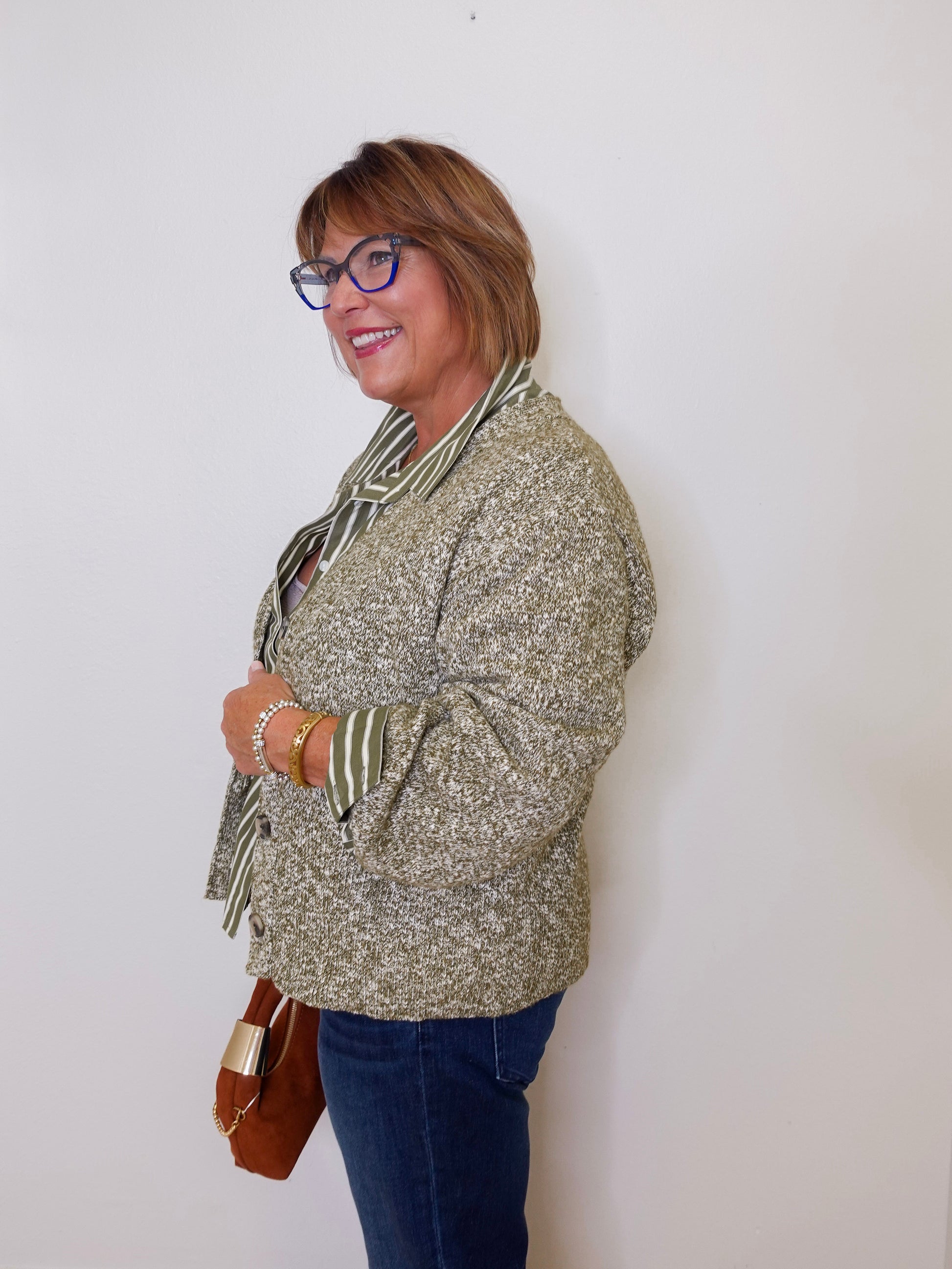 Woman wearing a patterned jacket and scarf against a white background