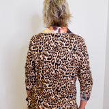 Person wearing a leopard print outfit with a white wall background