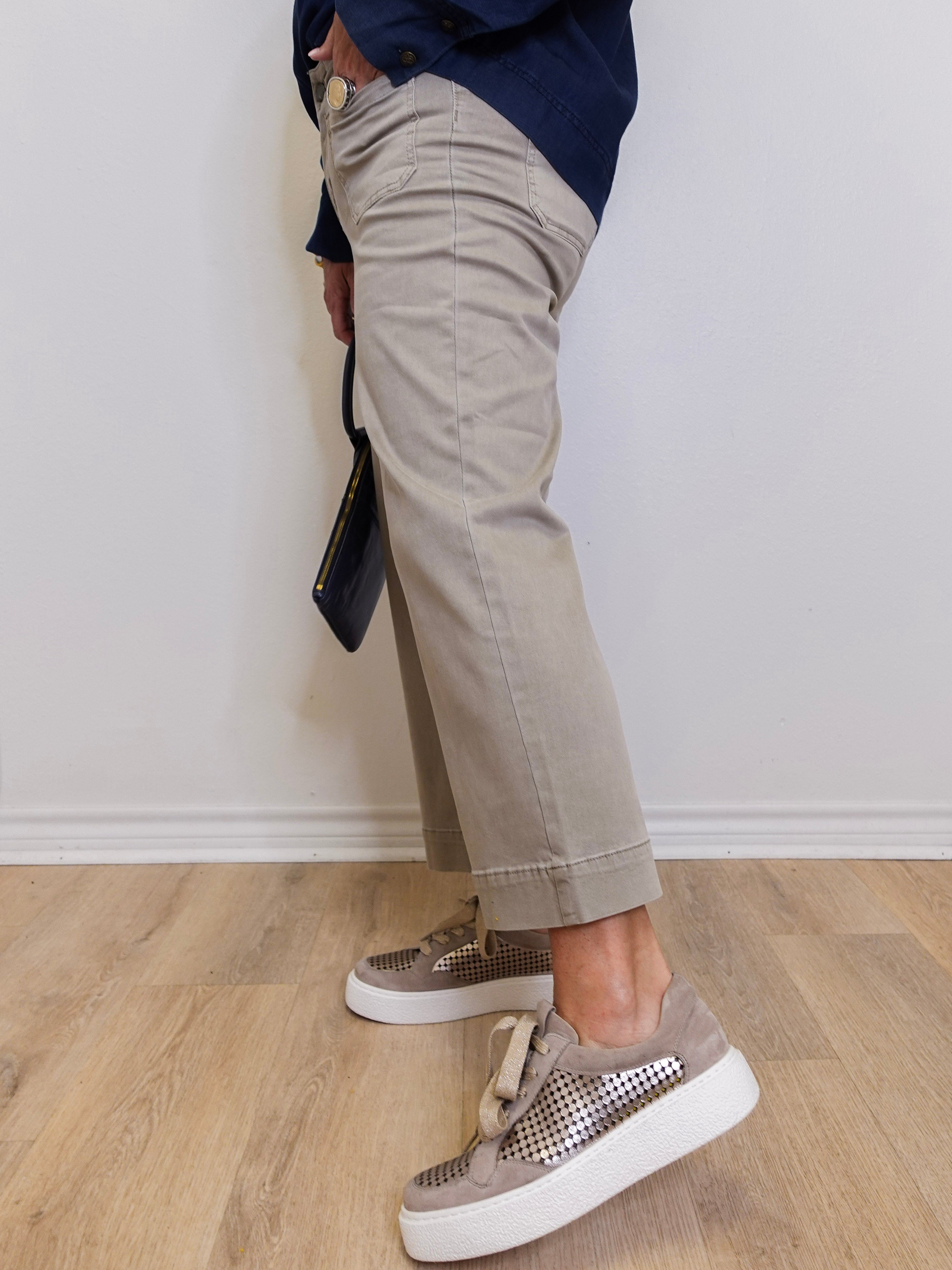 Woman wearing a cropped wide leg pant with front patch pockets in casual style in front a white background. 
