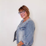 Woman wearing a denim jacket against a white background