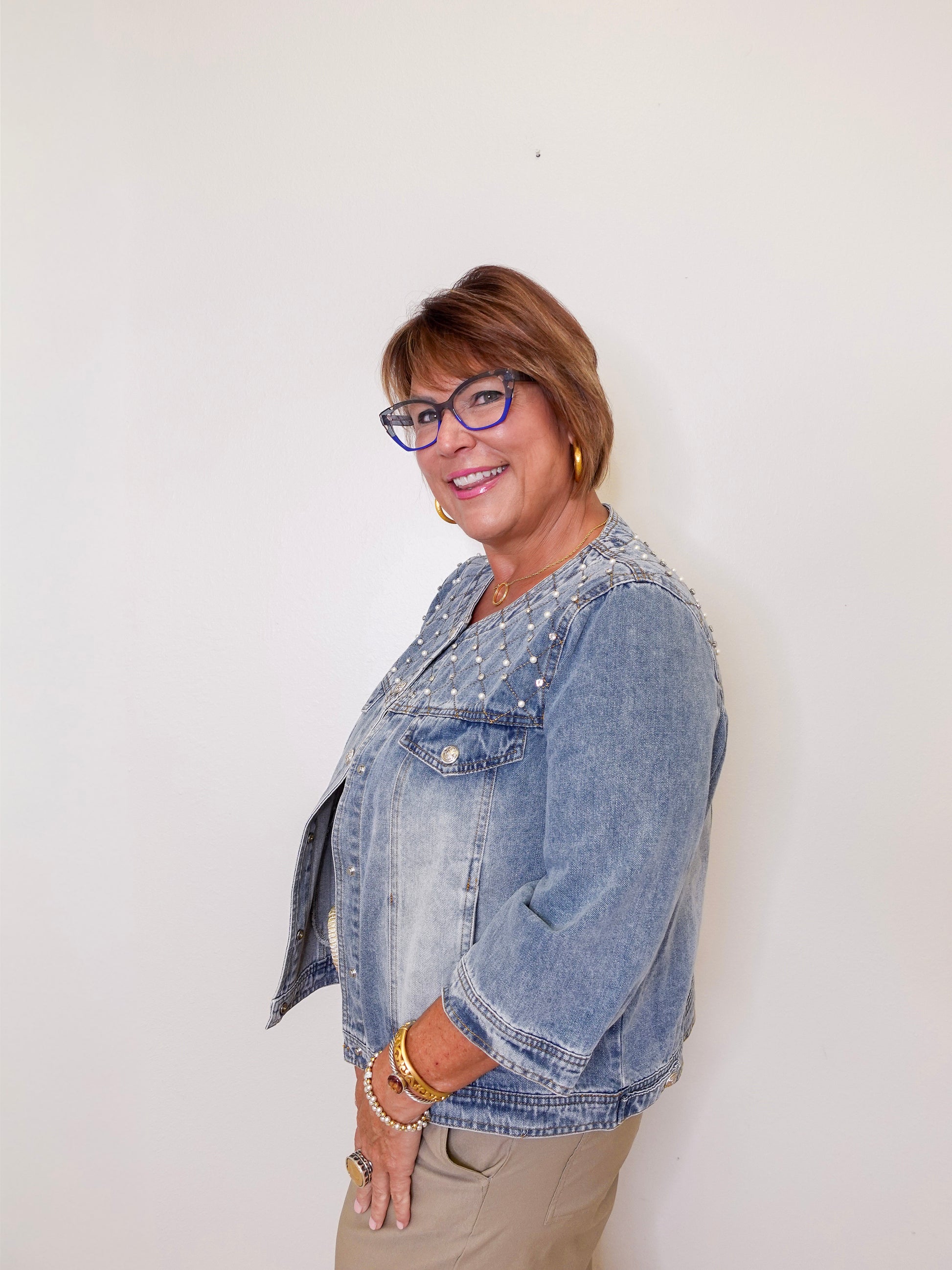 Woman wearing a denim jacket against a white background