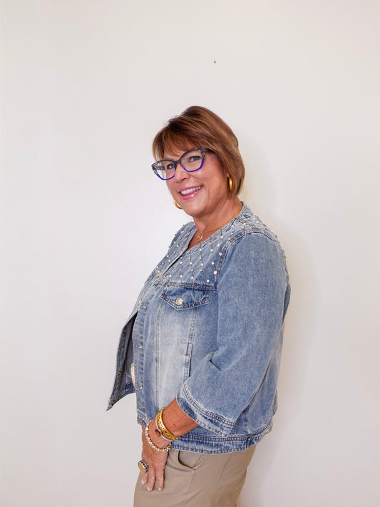 Woman wearing a denim jacket against a white background