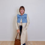woman wearing a long denim mix trench coat against a white background 