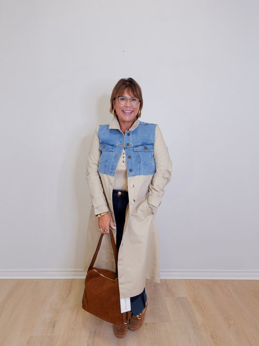woman wearing a long denim mix trench coat against a white background 