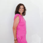 Woman wearing a bright pink outfit against a white background