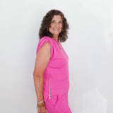 Woman wearing a bright pink outfit against a white background
