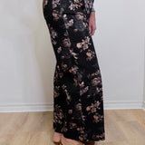 Person wearing black floral pants on a plain background